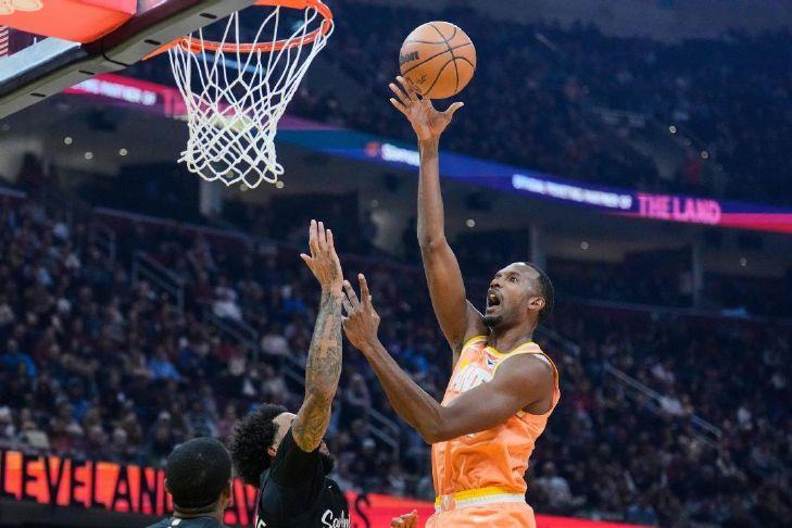 Cleveland Cavaliers center Evan Mobley, right, shoots over San Antonio Spurs forward Julian Champagnie, left, in the first half of an NBA basketball game Friday, Dec. 5, 2025, in Cleveland. (AP Photo/Sue Ogrocki)